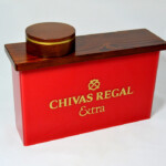 PLV en mélèze teinté-verni sur coffre plexiglas, sérigraphie or. PLV en mélèze teinté-verni sur coffre plexiglas, sérigraphie or.