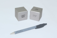 Petits cubes de 50mm de côté. Laque métallisée selon RAL et sérigraphie noire.